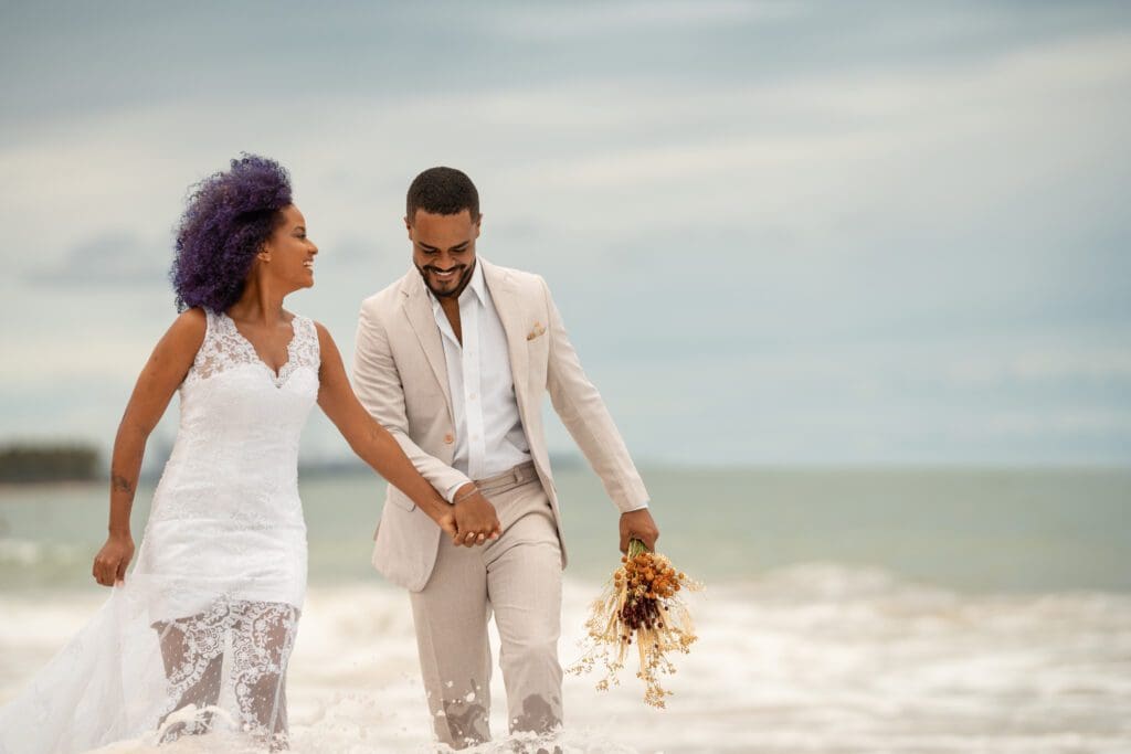 BRIDE AND GROOM WALKING ON BEACH . scaled