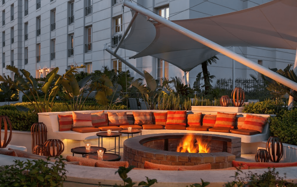 Outdoor fire pit with seating and a canopy.