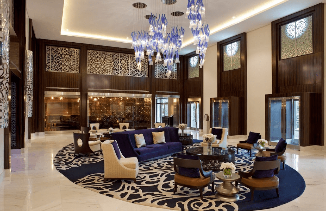 Luxury hotel lobby with ornate chandelier.