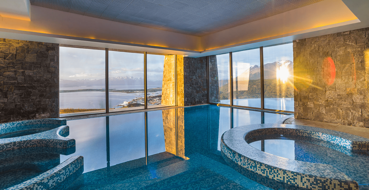 Indoor pool with mountain view and sunset.