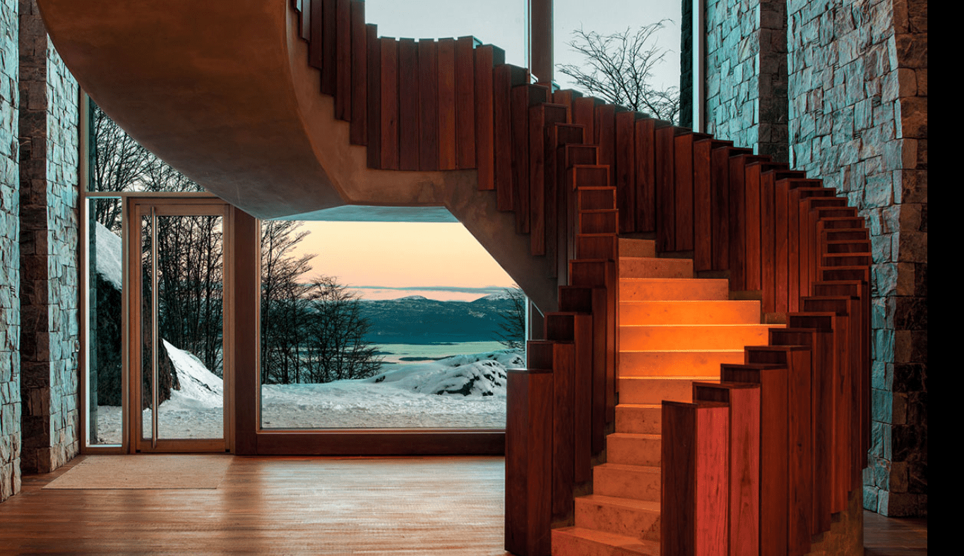 Modern wooden staircase with snowy mountain view.