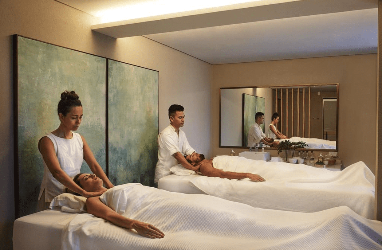 Two people receiving massages in a spa.