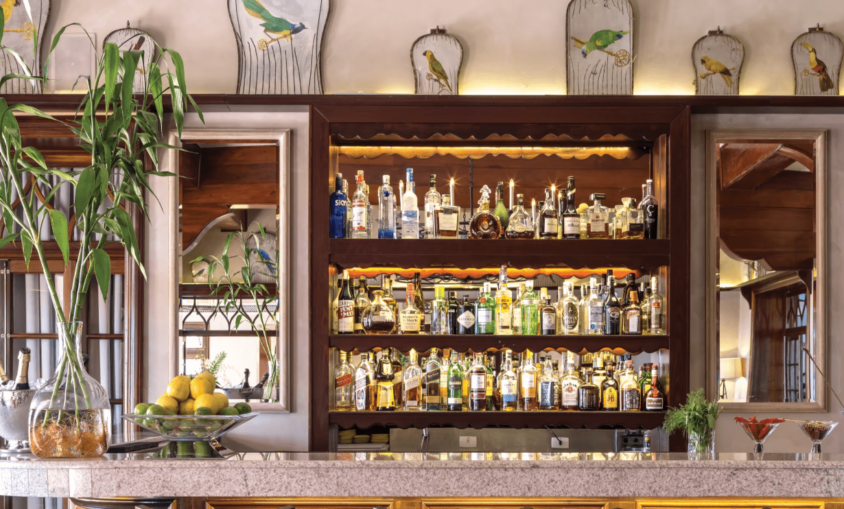 Bar counter with liquor bottles on shelves.