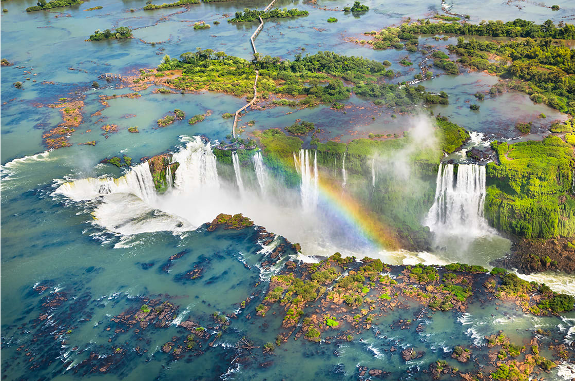 Aerial view of Iguazu Falls with a rainbow.