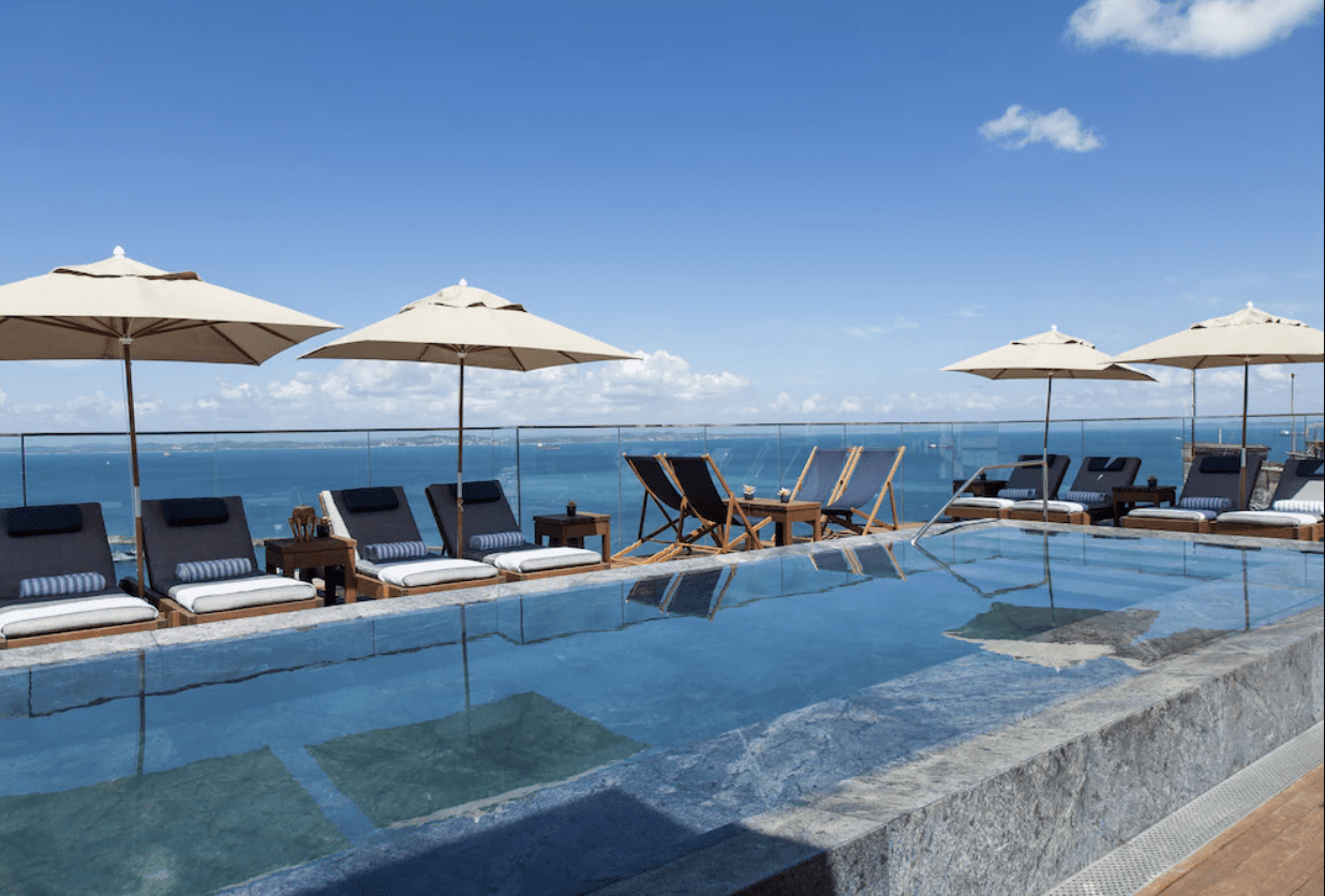 Rooftop pool with ocean view and loungers.