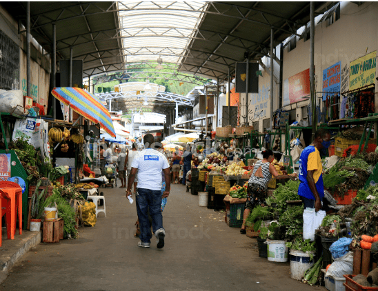 Busy outdoor market with produce and people.