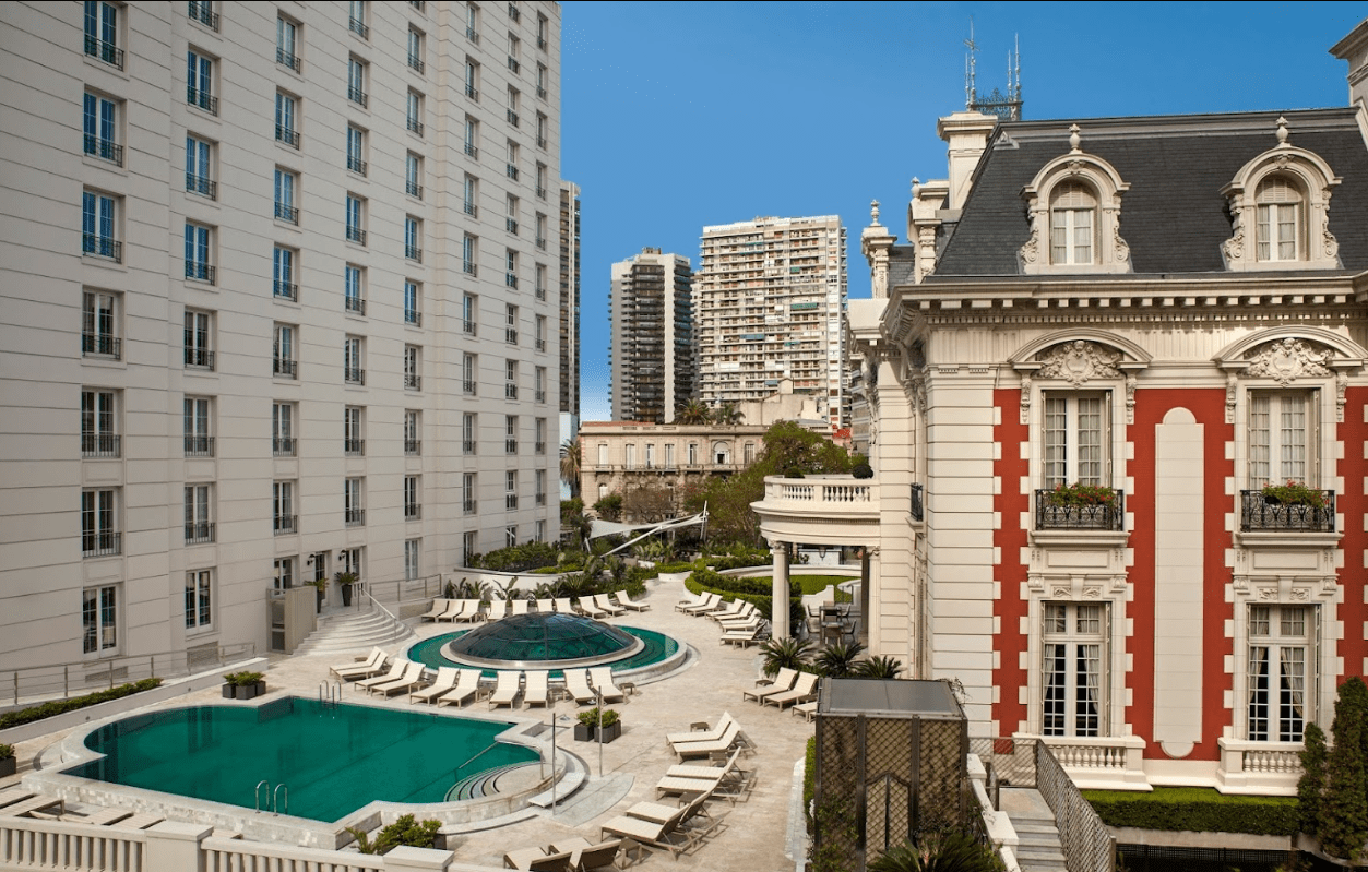 Poolside view of hotel building and city.