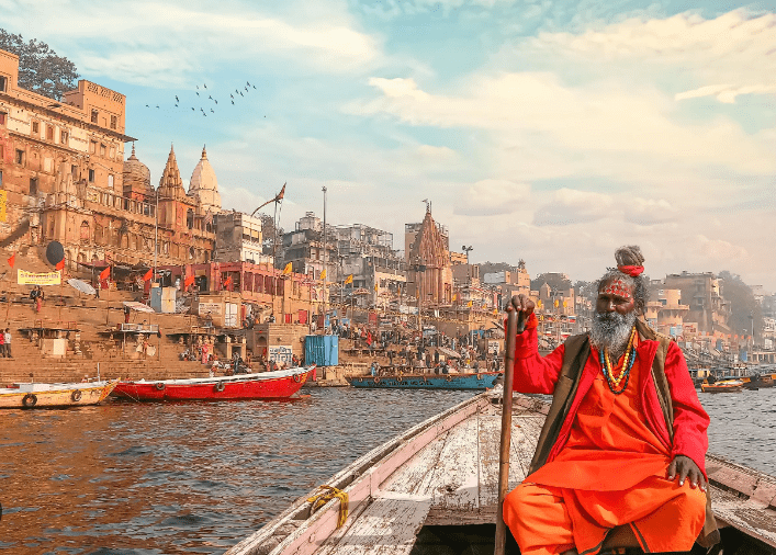 Man in orange robe on a boat in Varanasi.