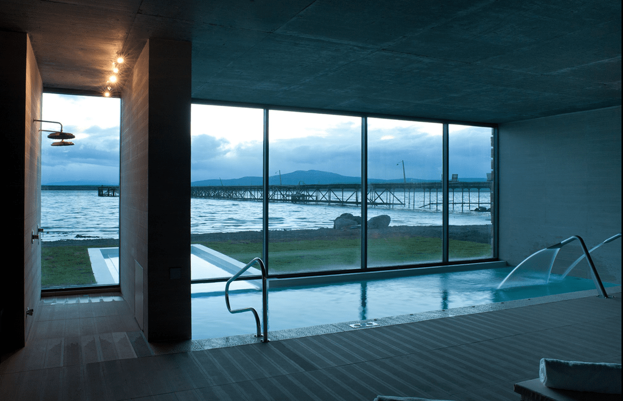 Indoor pool with ocean view and pier.