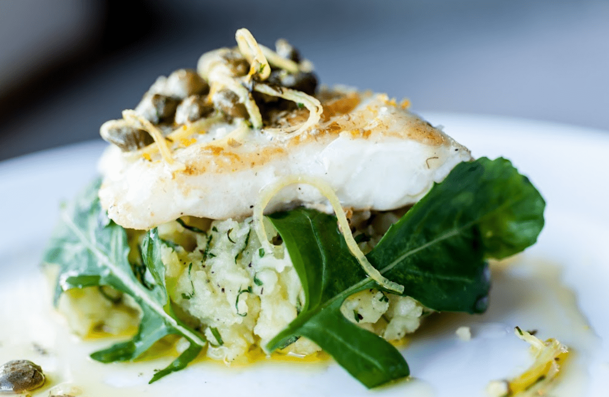 Pan-seared fish with mashed potatoes and greens.