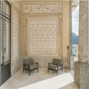 A balcony with chairs and a view of lake como.