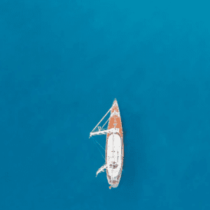 A white sailboat floating in the blue water.