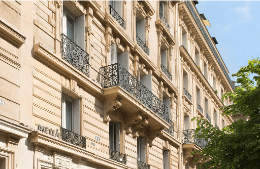 Beige building with balconies and windows.