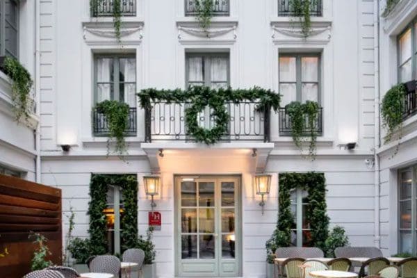 White building with balcony and patio furniture.