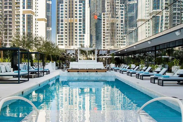 Poolside lounge chairs with city view.