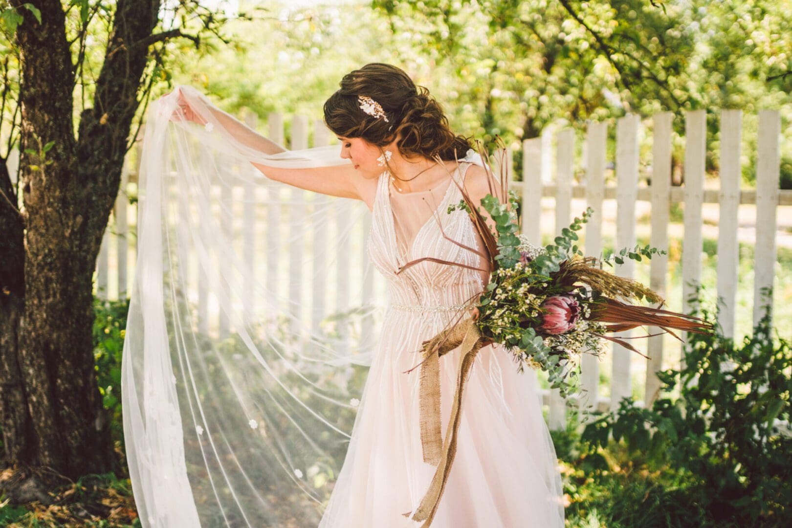 Bride in a pink gown holding flowers.