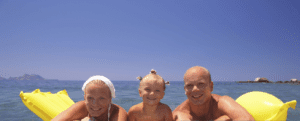 A group of people on a yellow raft in the ocean.