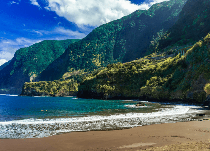 Secluded beach with green cliffs.