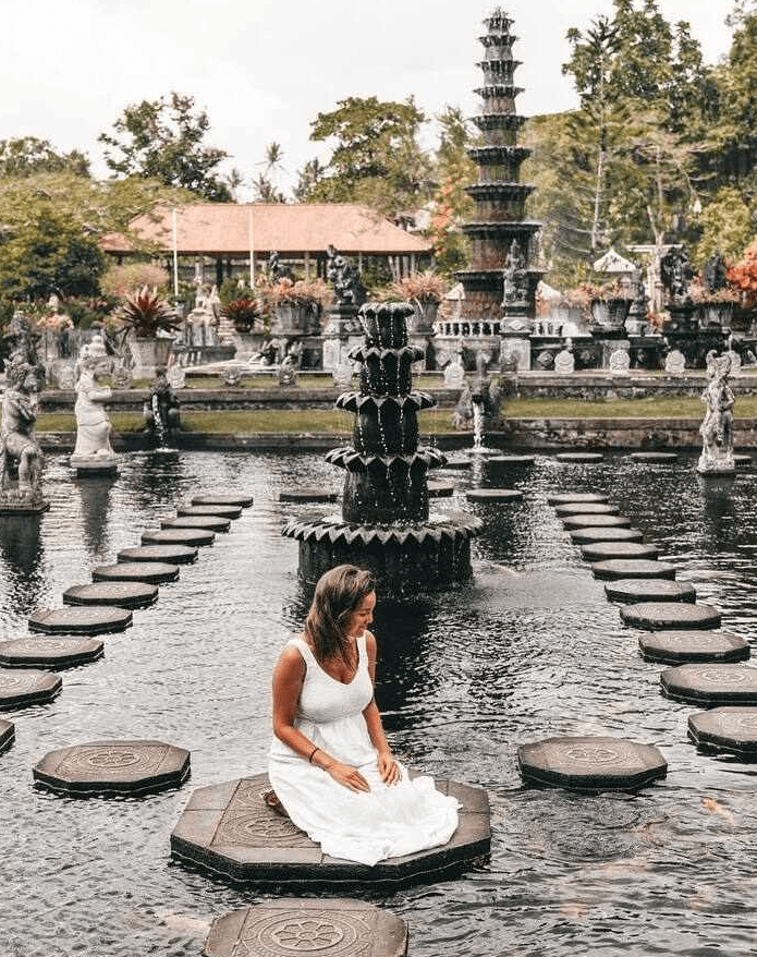 Woman in white dress at a water temple.