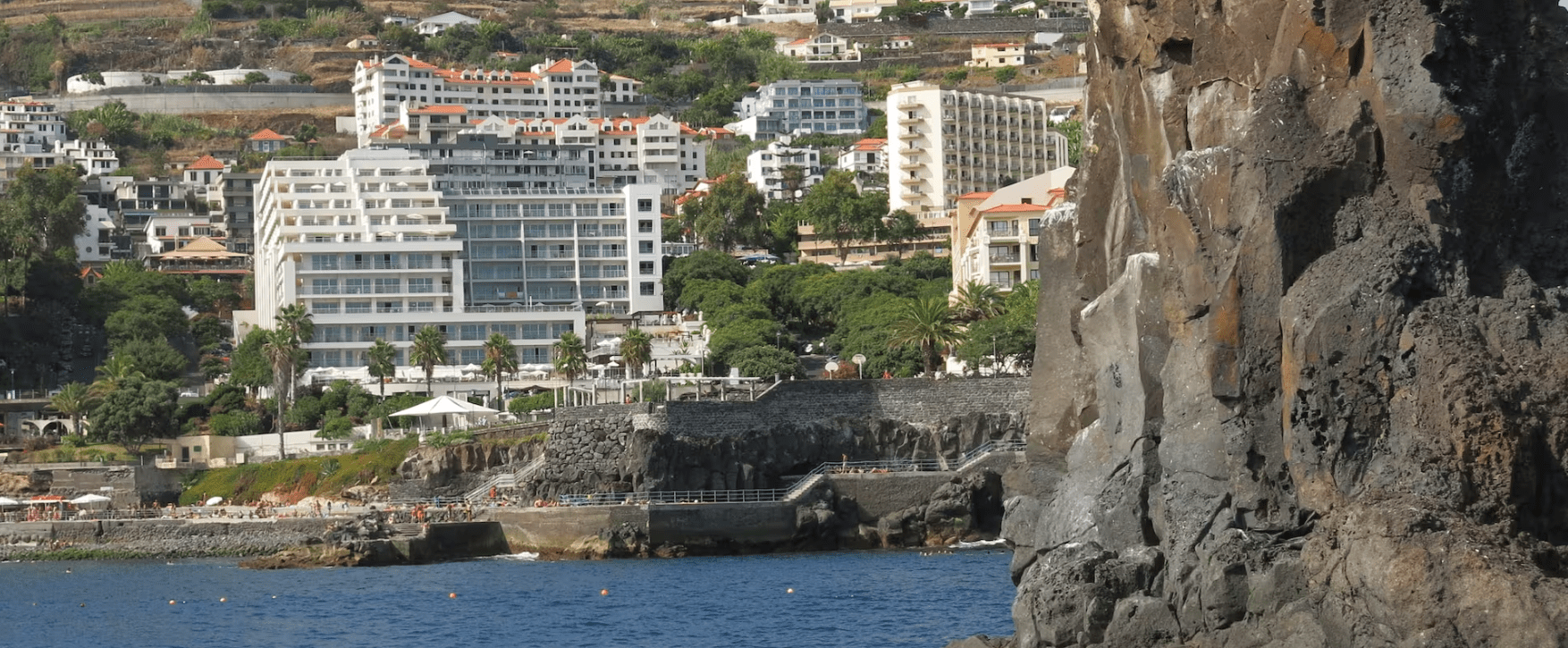 A cliff overlooking the ocean and buildings.