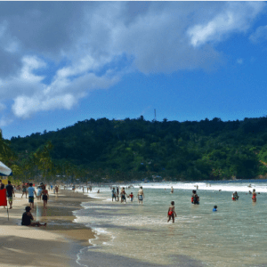 A beach with a lot of people on it.