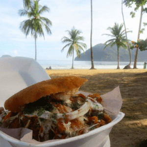 A sandwich on a plate on the beach.