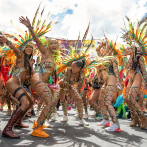 A group of dancers in colorful costumes on a street.