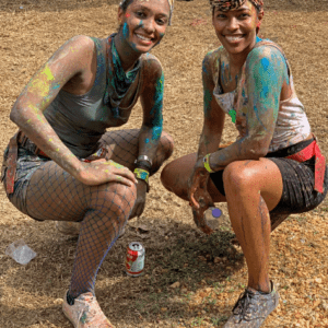 Two women with paint on their faces posing for a photo.