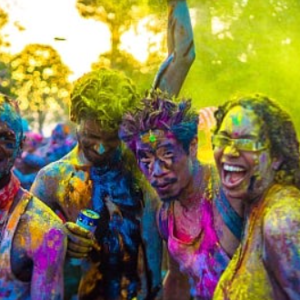 A group of people dressed in colorful paint at a holi festival.