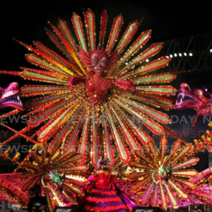 A colorful carnival costume is on display at night.