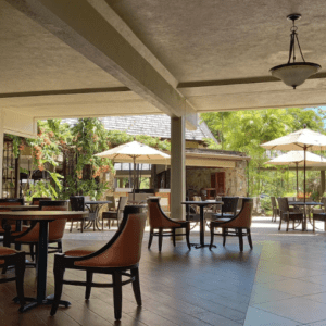 A restaurant with tables, chairs, and umbrellas.