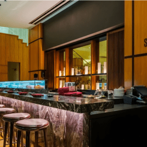 A sushi bar with stools and a counter.