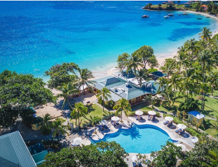 Aerial view of resort with pool and beach.