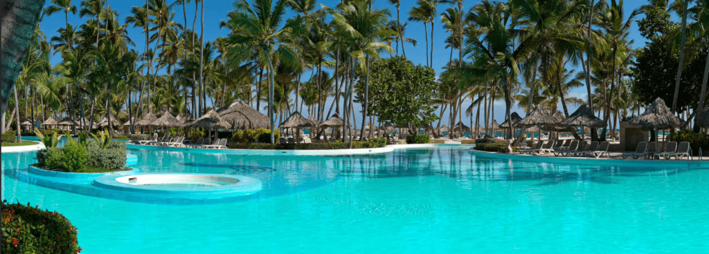 Palm trees and a pool in a tropical resort.