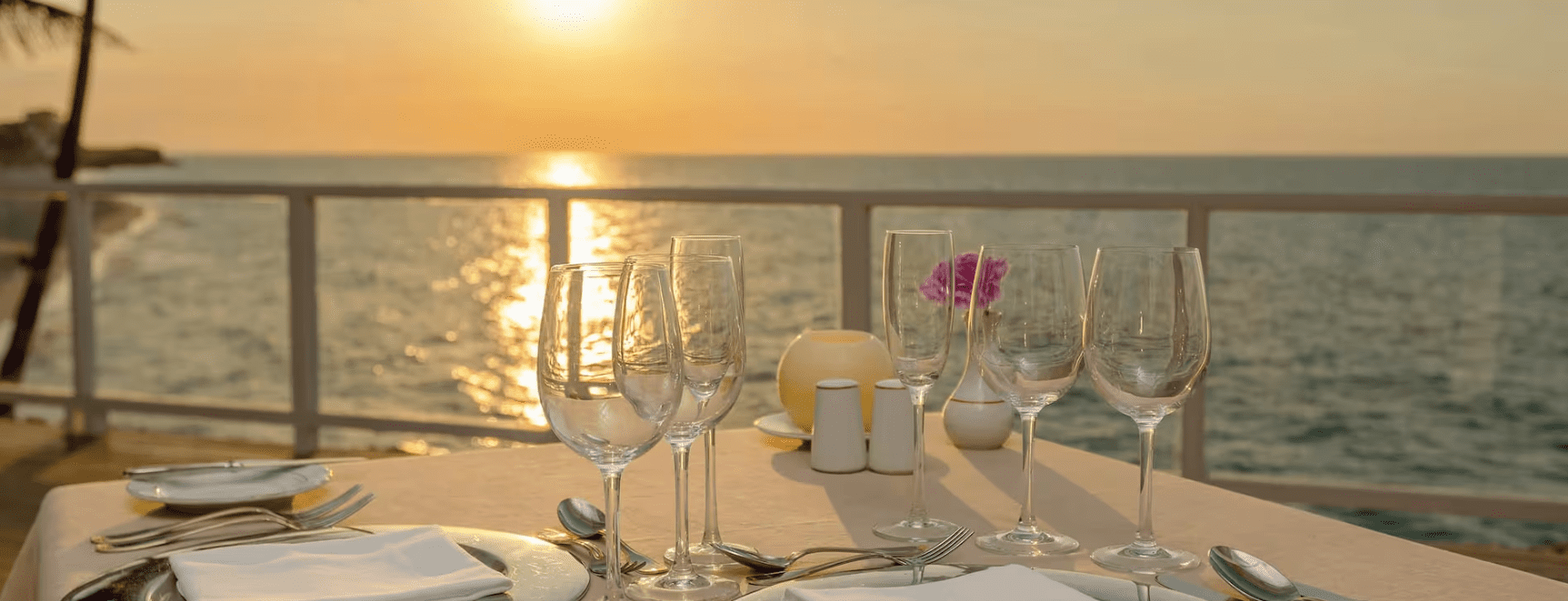 Oceanfront table setting with sunset.