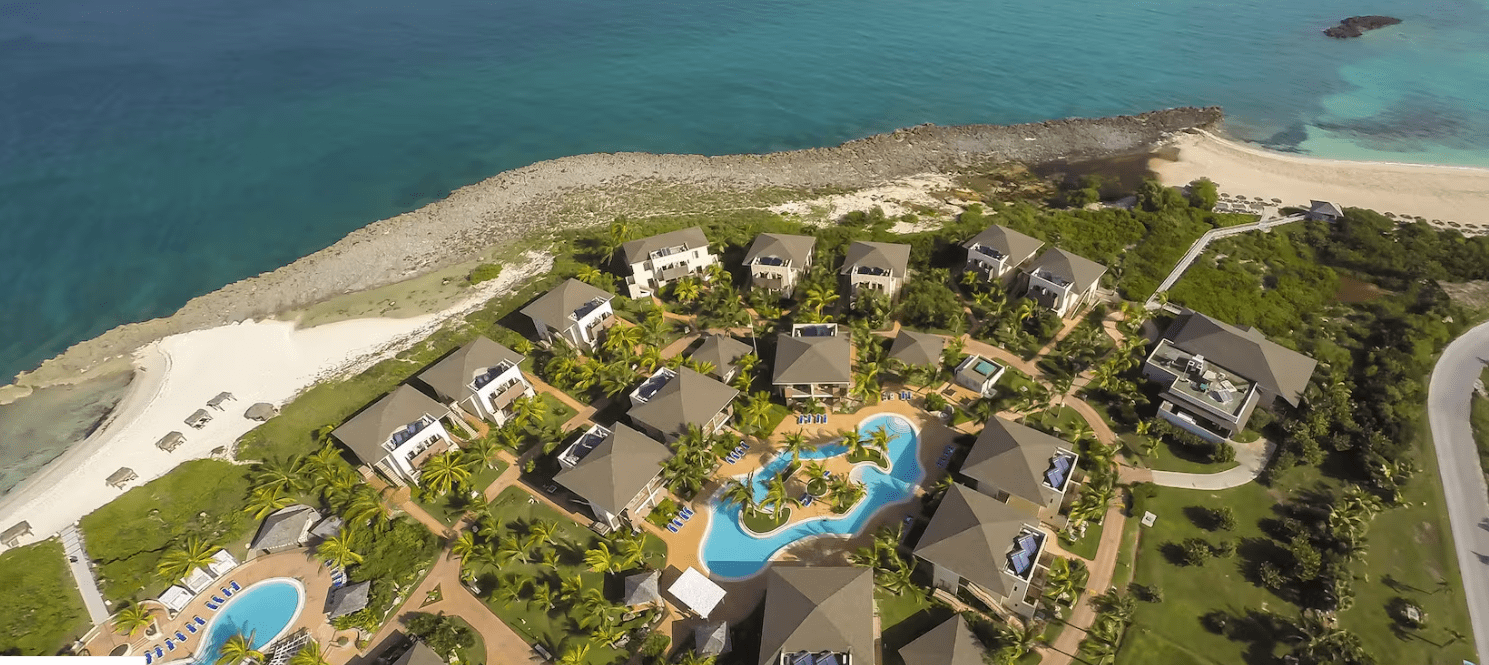 Aerial view of resort with pool and beach.