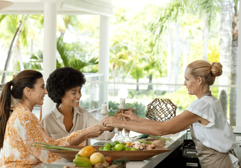 Three women enjoying drinks and fruit.