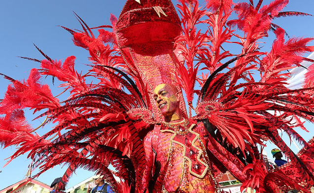 A man in a fashion show wearing red costume.