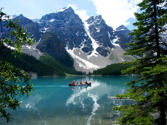 Canoe on turquoise lake with mountains.