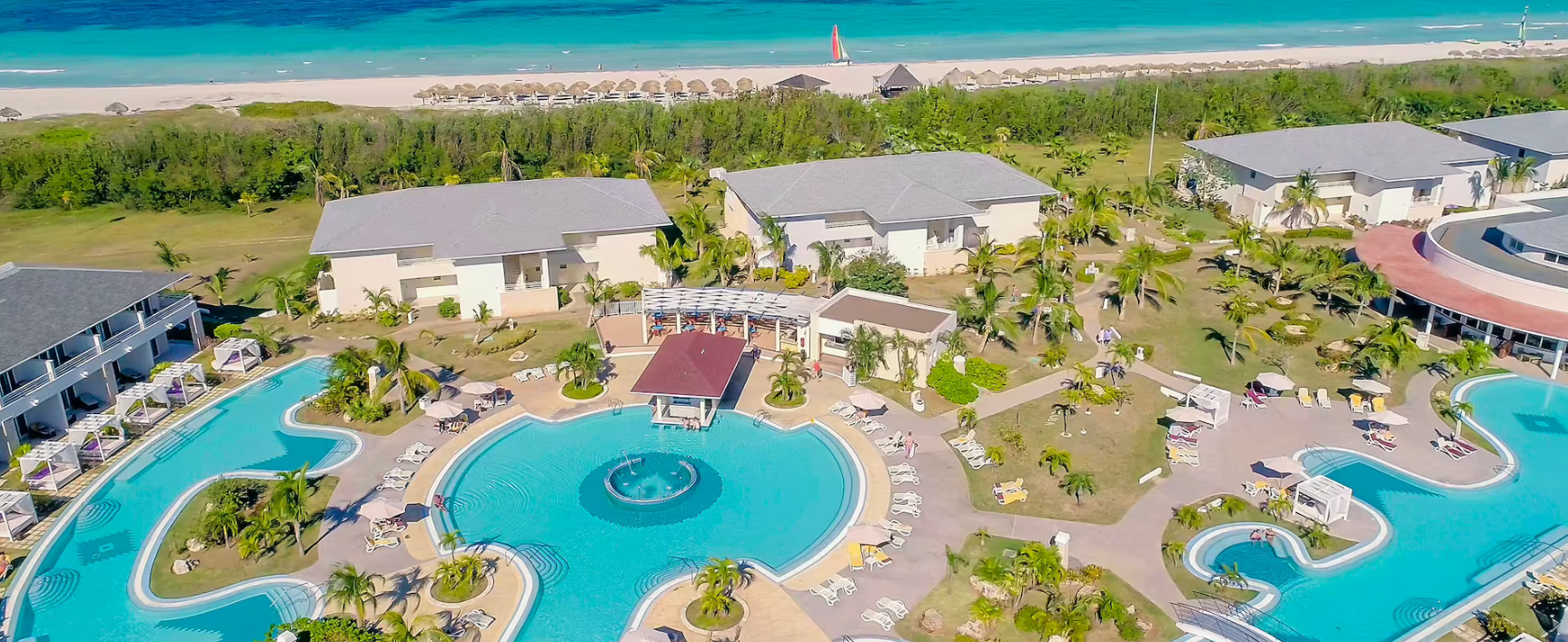 Aerial view of resort with pool and beach.