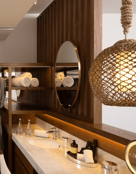 Modern bathroom with wooden vanity and woven light fixture.