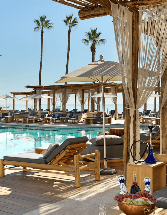 Poolside lounge chairs with a view of the ocean.