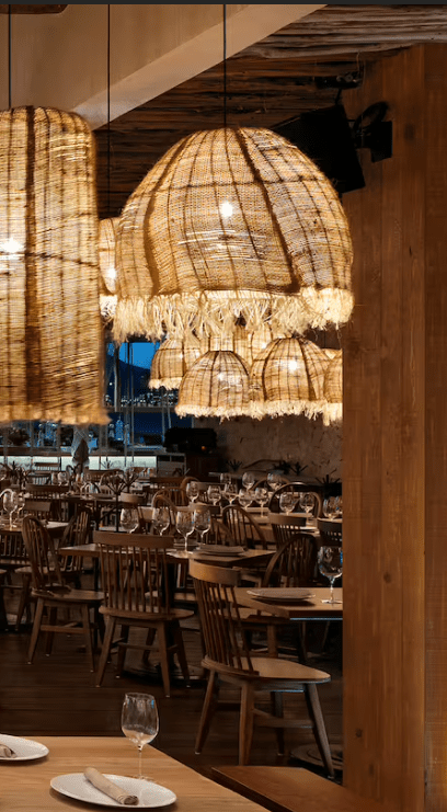 Wooden chairs and woven light fixtures in a restaurant.