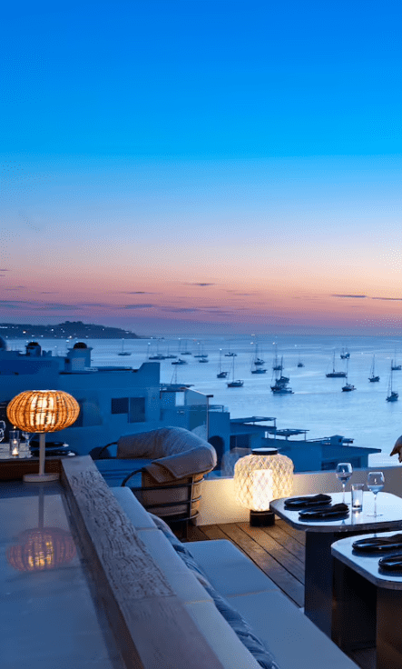 Outdoor patio with sunset view and boats.