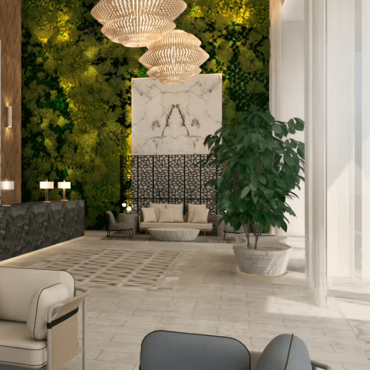 Modern lobby with green wall and chandeliers.