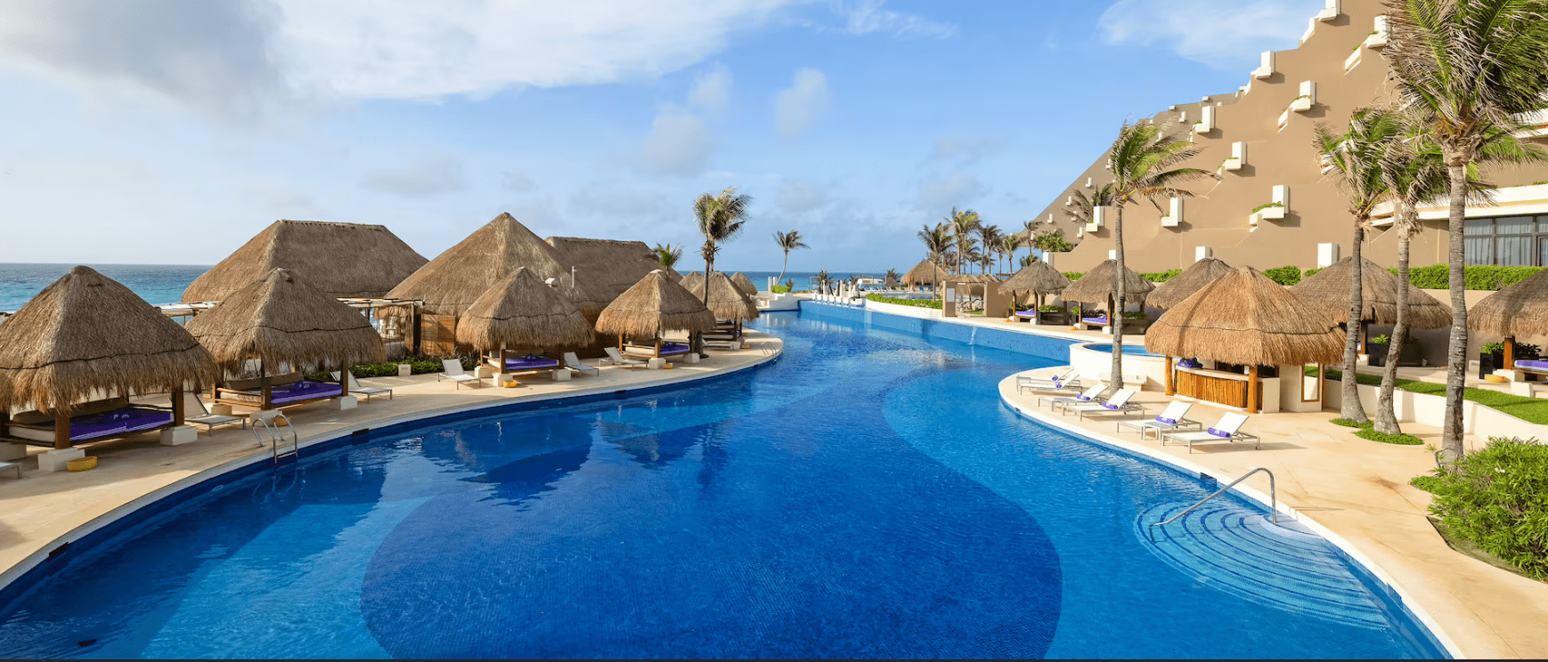 Resort pool with thatched cabanas.