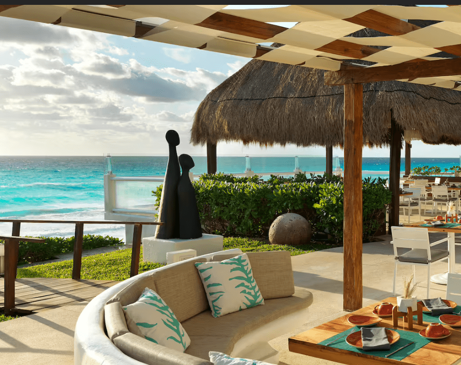 Ocean view patio with sculpture and table setting.