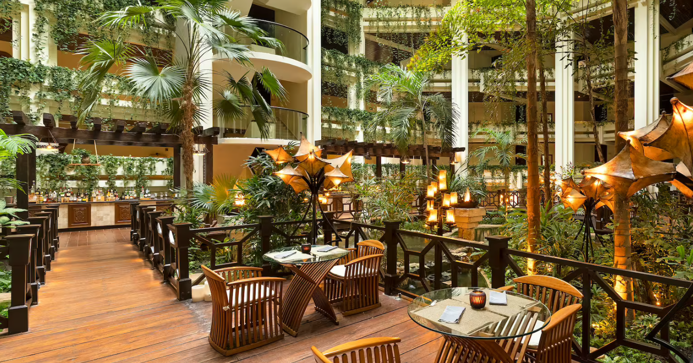 Tropical patio dining with lush greenery.