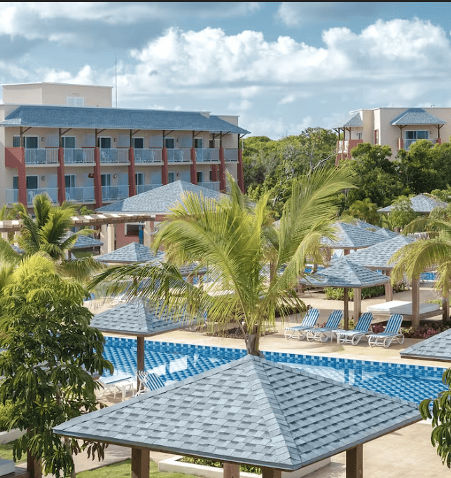 Resort pool with palm trees and cabanas.