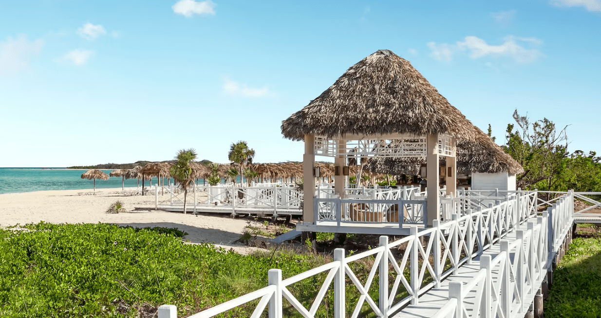 Beachfront gazebo with white walkway.